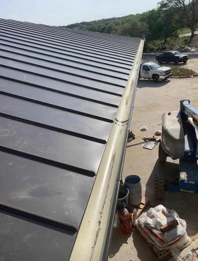 Standing seam panel and gutter detail on a metal roofing jobsite in Tiverton
